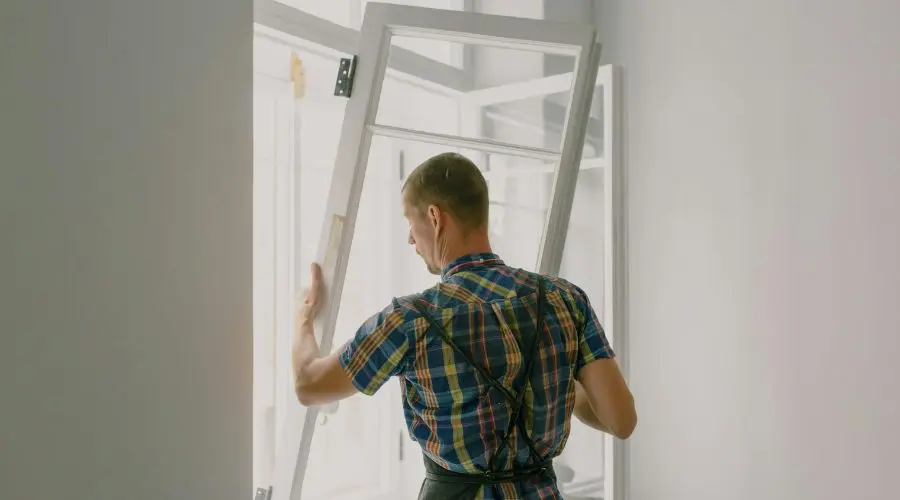Homme qui installe une fenêtre écoénergétique à bon prix